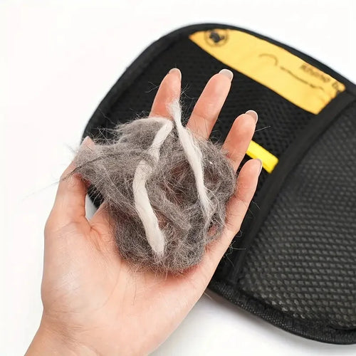 Hand met een pluk dierenhaar van de elektrostatische handschoen